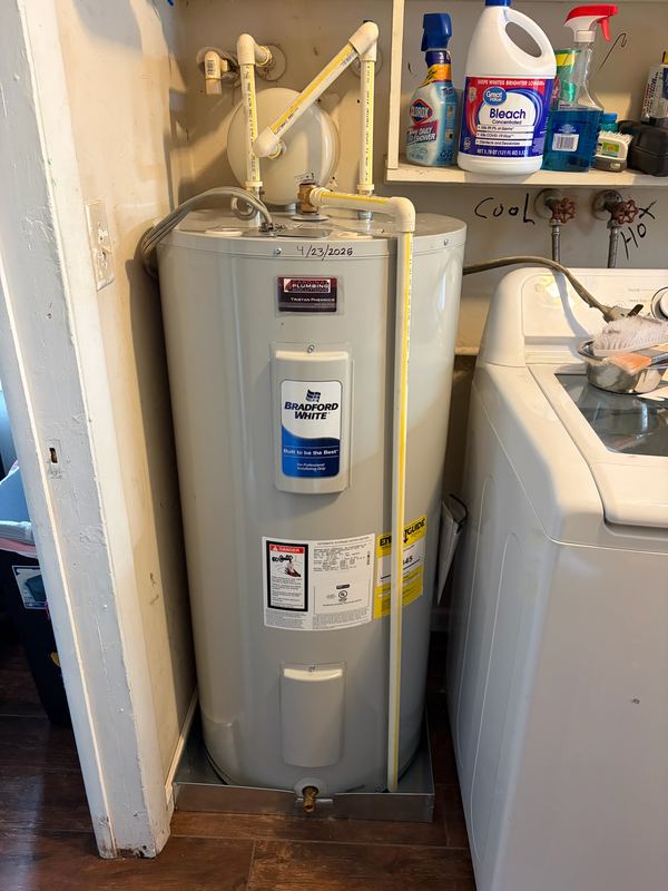 Electric water heater replaced in a laundry closet and dated on install